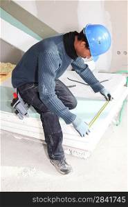 Man measuring insulation boards