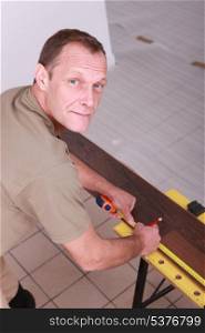 Man measuring laminate flooring