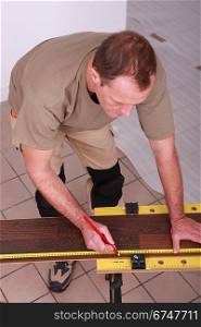 Man measuring slat parquet
