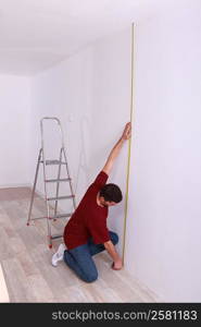 Man measuring wall