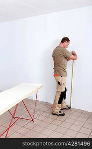 Man measuring wall