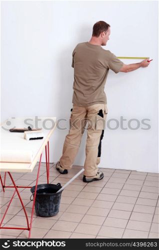 Man measuring wall