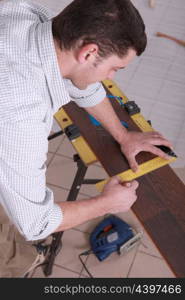 Man measuring wood flooring