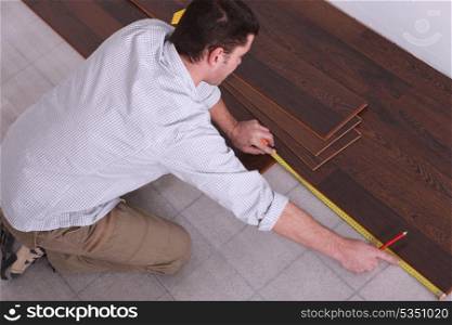 Man measuring wooden flooring