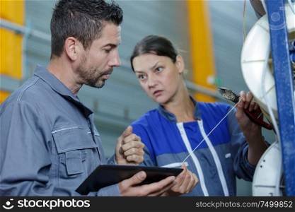 man mechanic and woman discussing an issue