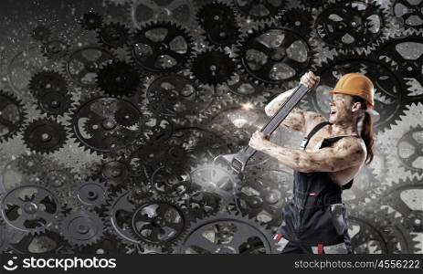 Man mechanic. Strong man mechanic in uniform with spanner fixing mechanism
