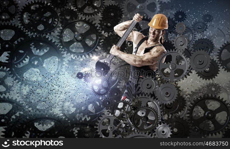 Man mechanic. Strong man mechanic in uniform with spanner fixing mechanism