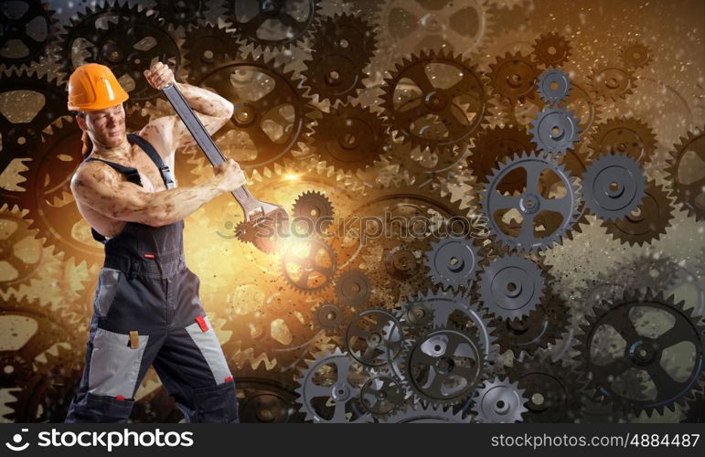 Man mechanic. Strong man mechanic in uniform with spanner fixing mechanism