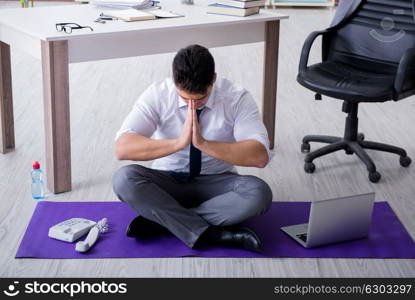 Man meditating in the office to cope with stress