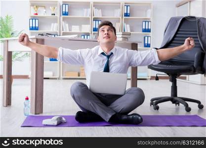 Man meditating in the office to cope with stress. The man meditating in the office to cope with stress