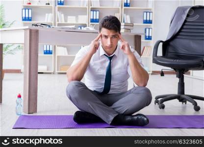 Man meditating in the office to cope with stress. The man meditating in the office to cope with stress