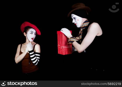man mime gives to the woman gift in red box