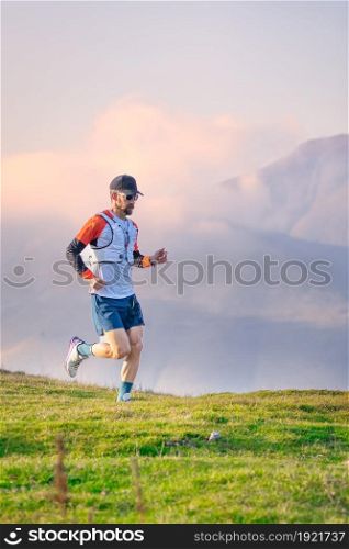 Man mountain runner trains on meadows
