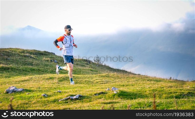 Man mountain runner trains on meadows