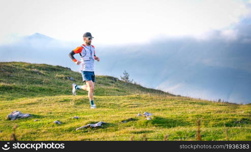 Man mountain runner trains on meadows