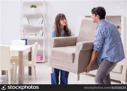 Man moving armchair in the living room