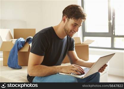 Man Moving Into New Home Using Laptop Computer