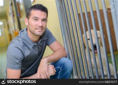 Man next to dog in kennel