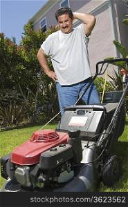 Man observing lawn mower in garden