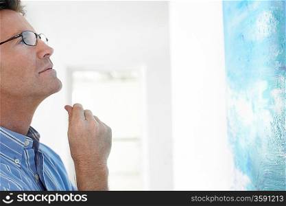 Man observing painting in art gallery