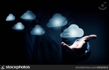 Man offering cloud computing concept. Close view of businessman showing cloud icons in palm