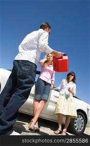 Man offering gas can to women