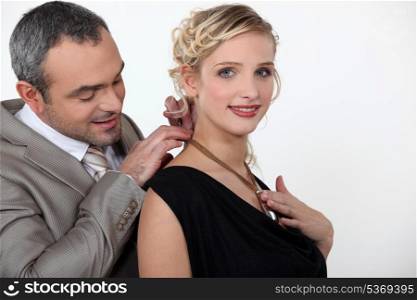 man offering his girlfriend a necklace