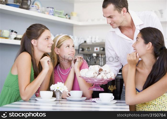 Man offering sweet treats to three young women