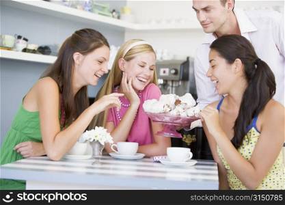 Man offering sweet treats to three young women
