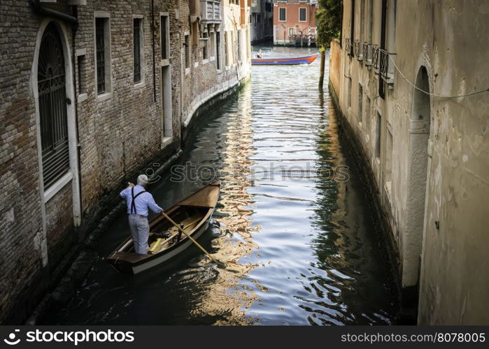 Man on a boat in Venice. Pass thru the channel