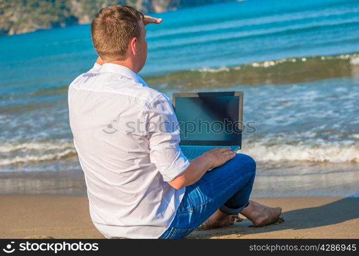 man on a desert island with a laptop looking for a ship