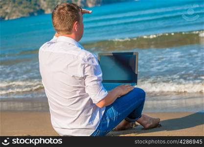 man on a desert island with a laptop looking for a ship