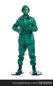 Man on a green toy soldier costume standing with riffle isolated on white background.