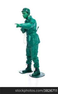Man on a green toy soldier costume with riffle poiting with his forefinger isolated on white background.