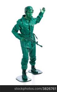Man on a green toy soldier costume with riffle waving to be followed isolated on white background.