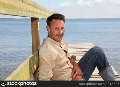 Man on a pontoon by a lake in summer