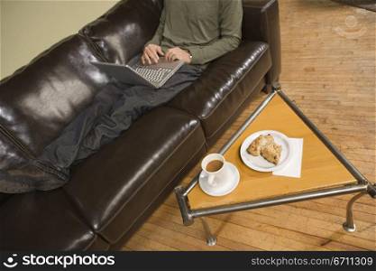 Man on a sofa with a laptop