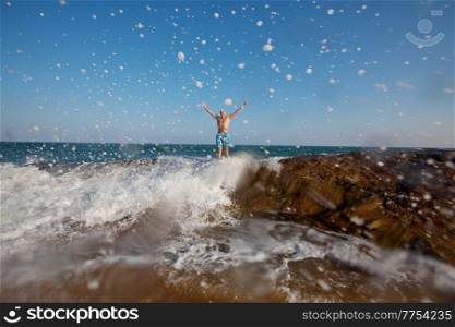man on a tropical beach amidst splashing water