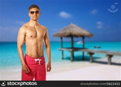 Man on beach with jetty at Maldives. Collage.