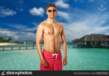 Man on beach with water bungalows at Maldives. Collage.