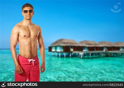 Man on beach with water bungalows at Maldives. Collage.