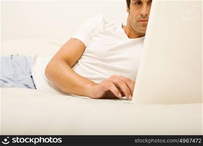 Man on bed using laptop computer
