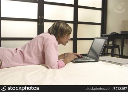Man on bed with laptop