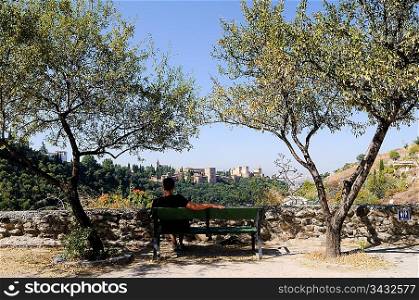 Man on bench facing out to a landscape view