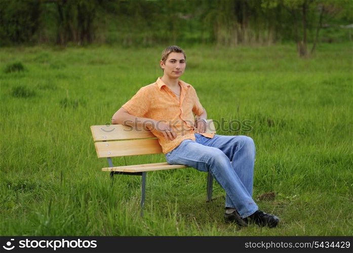 Man on bench in park. Shallow DOF. Outdoor portrait