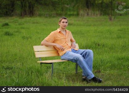 Man on bench in park. Shallow DOF. Outdoor portrait