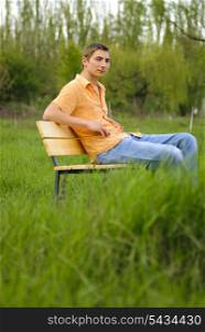 Man on bench in park. Shallow DOF. Outdoor portrait