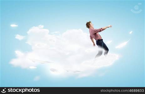 Man on cloud. Young man in casual walking on cloud high in sky