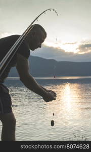 Man on fishing with rod. Mountain lake