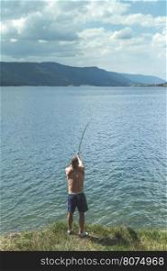 Man on fishing with rod. Mountain lake. Bulgaria
